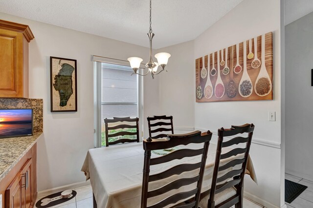 dining area with an inviting chandelier, light tile patterned flooring, and baseboards