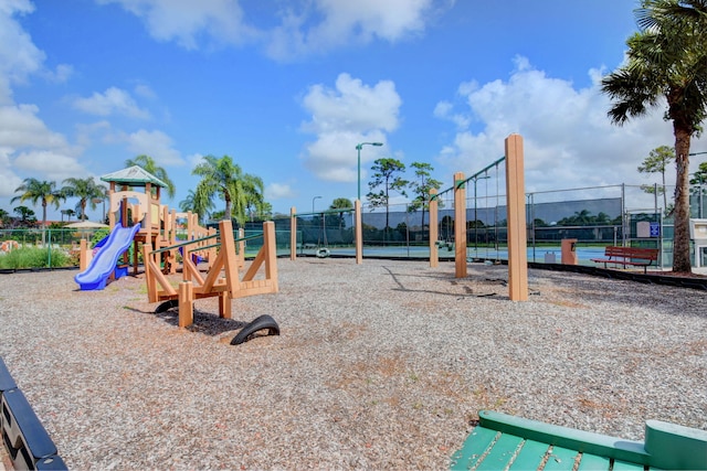 community play area featuring a tennis court and fence