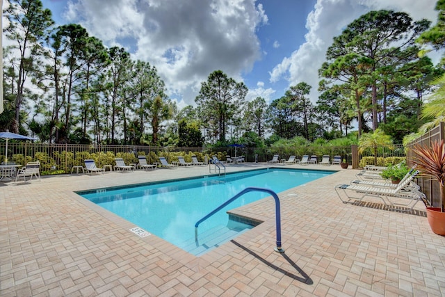 pool with fence and a patio area