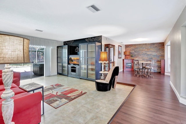 621 NW 71st Ave, Plantation, FL 33317 - living area featuring an accent wall, wood walls, wood finished floors, and baseboards