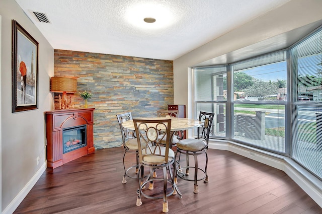 621 NW 71st Ave, Plantation, FL 33317 - dining space with a textured ceiling, baseboards, dark wood-type flooring, and a glass covered fireplace
