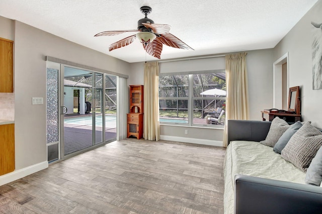 621 NW 71st Ave, Plantation, FL 33317 - living room featuring a ceiling fan, healthy amount of natural light, wood finished floors, baseboards, and a textured ceiling