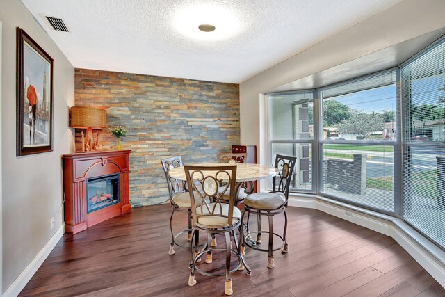 621 NW 71st Ave, Plantation, FL 33317 - dining room with a textured ceiling, dark wood-style floors, and a glass covered fireplace