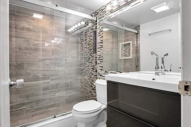 bathroom featuring vanity, toilet, and a stall shower