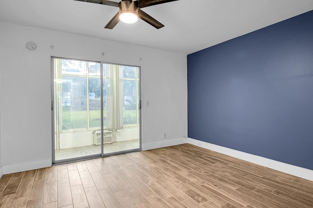 empty room featuring cooling unit, a ceiling fan, wood finished floors, and baseboards