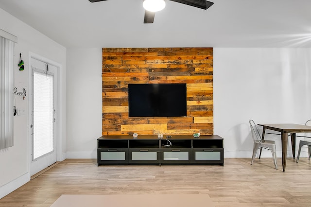 living room with baseboards, wood finished floors, ceiling fan, and plenty of natural light