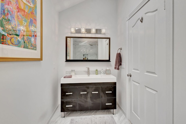 bathroom featuring baseboards, a shower, and vanity
