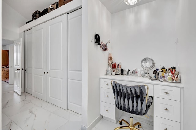 home office featuring baseboards, marble finish floor, and built in desk