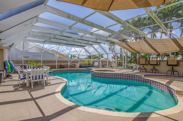 pool featuring a lanai, a patio, an in ground hot tub, and a fenced backyard