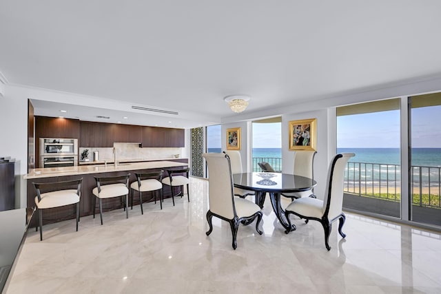 dining space with a water view and marble finish floor