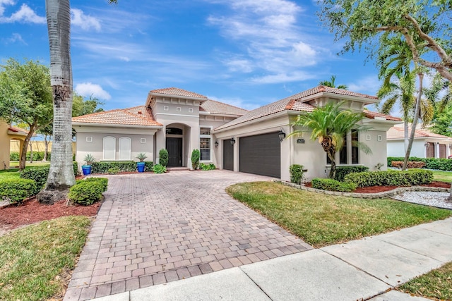 16211 Rosecroft Ter, Delray Beach, FL 33446 - mediterranean / spanish-style home with an attached garage, decorative driveway, stucco siding, and a tiled roof