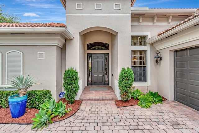 16211 Rosecroft Ter, Delray Beach, FL 33446 - property entrance with a garage, stucco siding, and a tile roof