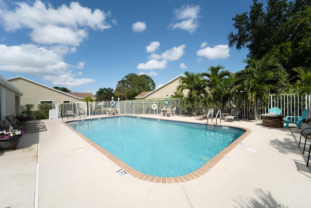 community pool featuring fence and a patio area