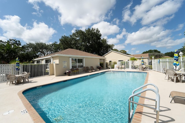 pool with a patio and fence
