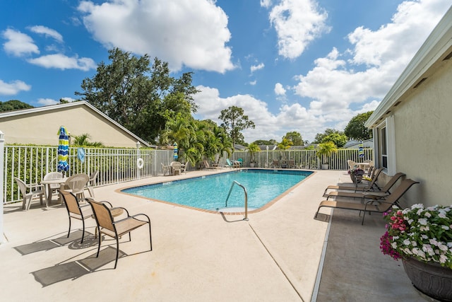pool featuring fence and a patio