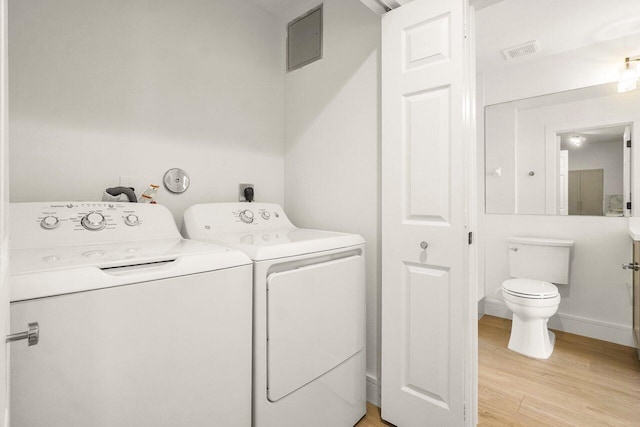 720 S Sapodilla Ave Unit 105, West Palm Beach, FL 33401 - washroom featuring washer and dryer, light wood finished floors, and baseboards