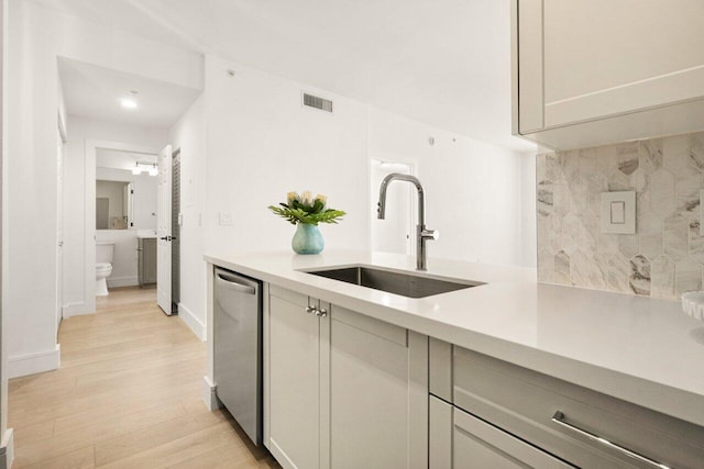 720 S Sapodilla Ave Unit 105, West Palm Beach, FL 33401 - kitchen with dishwasher, a sink, light wood-type flooring, and light countertops