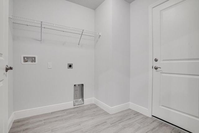 clothes washing area featuring hookup for an electric dryer, baseboards, hookup for a washing machine, light wood-type flooring, and laundry area