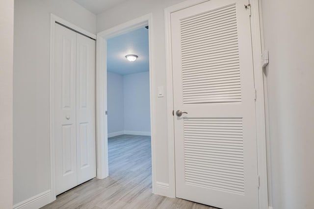 hall with light wood finished floors and baseboards