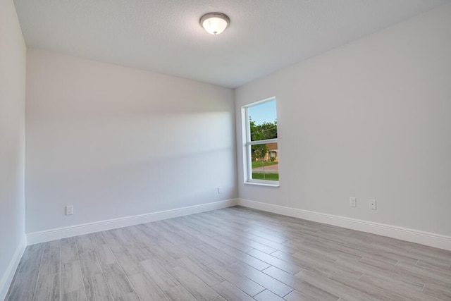unfurnished room with wood finished floors and baseboards