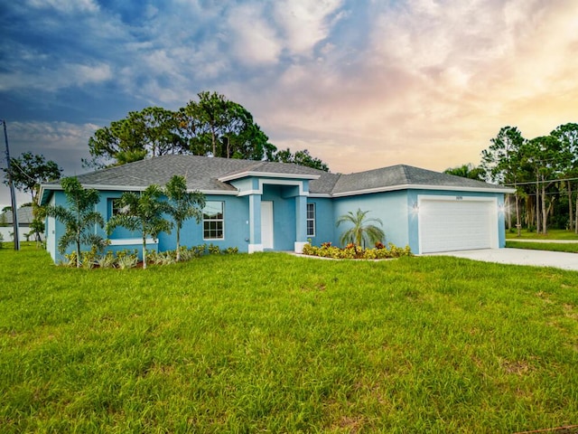 view of front of property featuring a front lawn, driveway, a garage, and stucco siding
