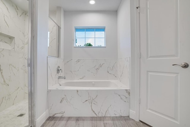 bathroom with a garden tub, recessed lighting, and a marble finish shower
