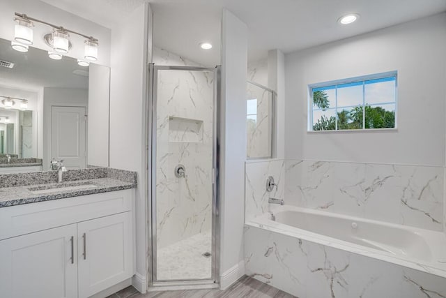 bathroom featuring vanity, recessed lighting, a bath, and a marble finish shower
