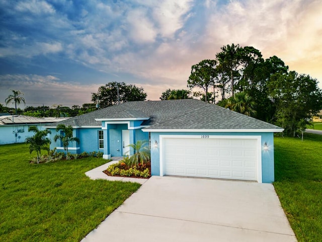 ranch-style home with driveway, a lawn, and stucco siding