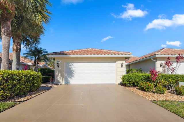 view of front facade featuring an attached garage, stucco siding, a tile roof, and concrete driveway