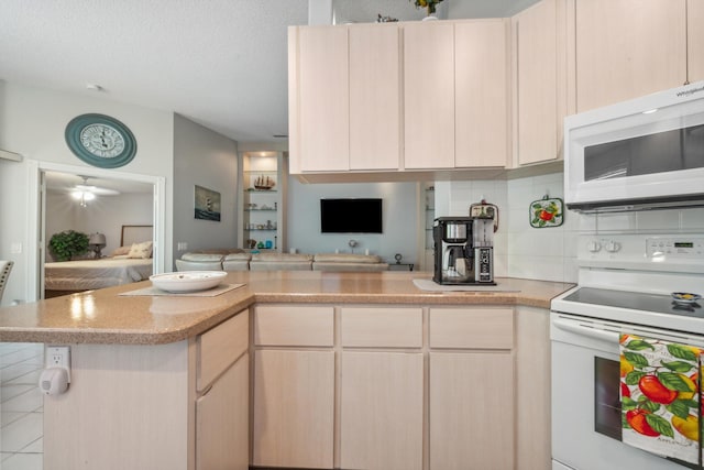 kitchen with light countertops, a peninsula, white appliances, and tasteful backsplash