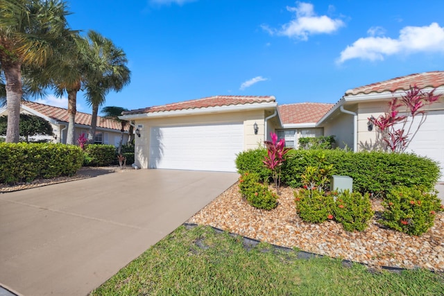 single story home with a garage, a tiled roof, concrete driveway, and stucco siding