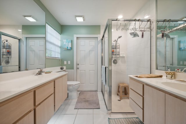 full bathroom featuring tile patterned floors, a sink, a shower stall, and tile walls