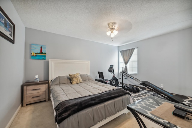 bedroom featuring baseboards, a textured ceiling, ceiling fan, and carpet