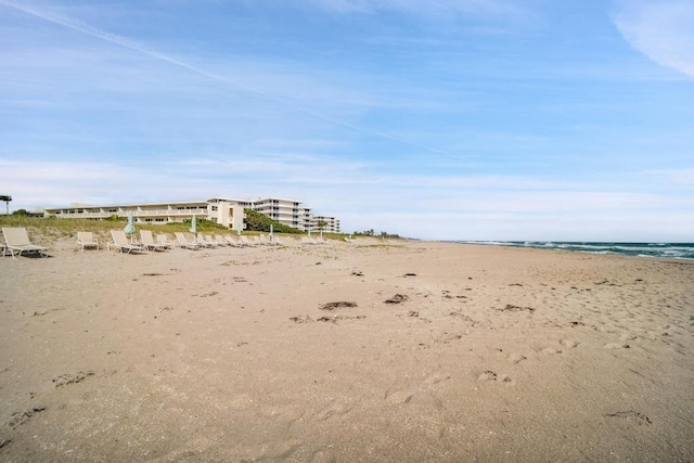 view of yard featuring a beach view and a water view