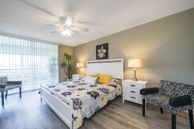 bedroom featuring access to outside, a textured ceiling, dark wood-style floors, and ceiling fan