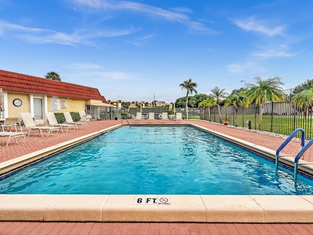 community pool featuring fence and a patio