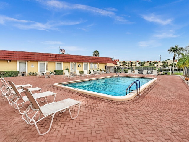 community pool featuring fence and a patio area