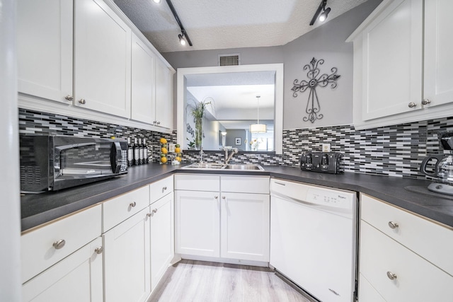 kitchen featuring visible vents, track lighting, dark countertops, a textured ceiling, and dishwasher