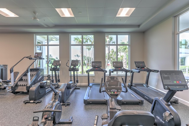 workout area featuring baseboards and a paneled ceiling