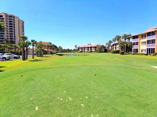 view of home's community with a yard, a water view, and view of golf course