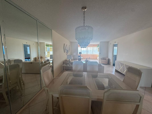 dining room featuring a chandelier, a textured ceiling, and light tile patterned flooring