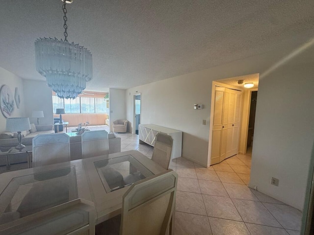 dining area featuring a chandelier, light tile patterned floors, and a textured ceiling