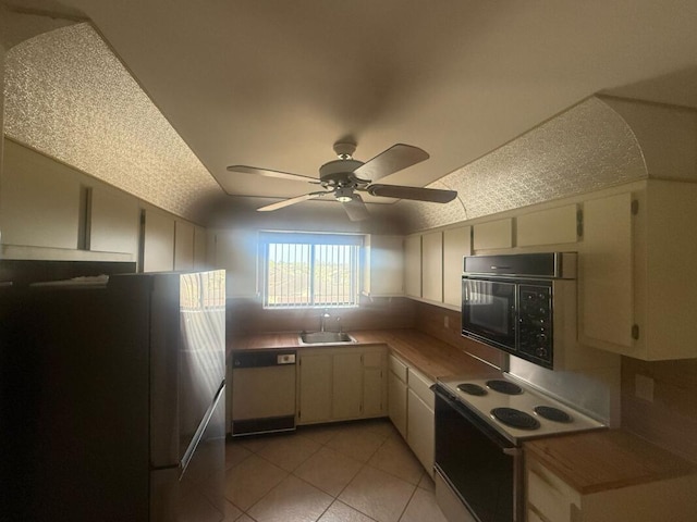 kitchen with white appliances, light tile patterned floors, a sink, a ceiling fan, and lofted ceiling