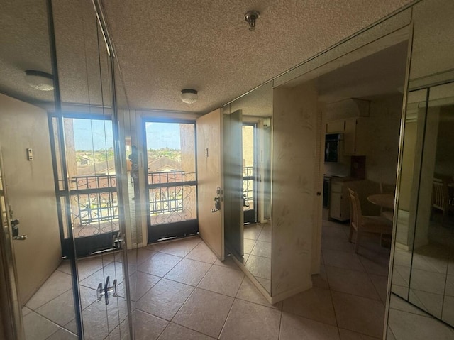 entryway with a textured ceiling and light tile patterned floors