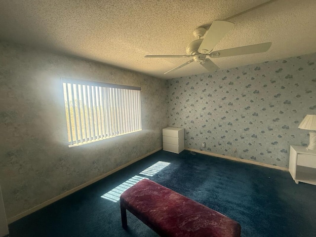 spare room with baseboards, a ceiling fan, a textured ceiling, and carpet