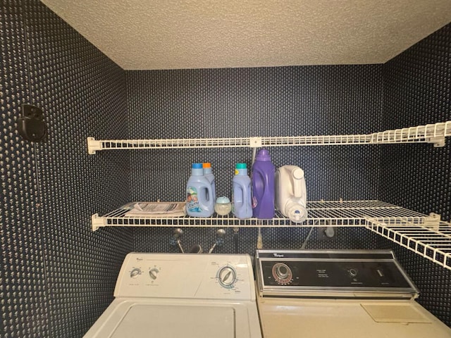 washroom featuring a textured ceiling, washer and clothes dryer, and laundry area