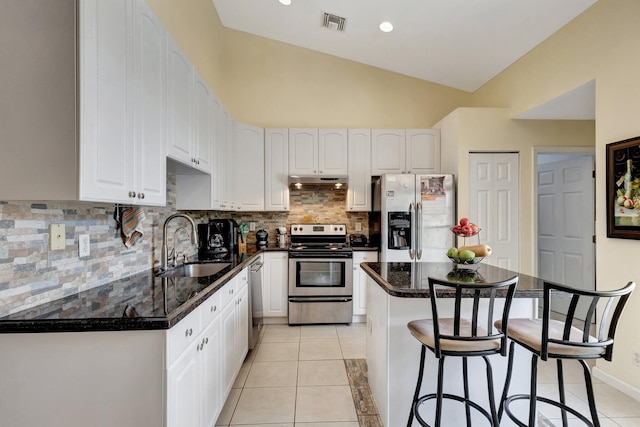 12820 87th St N, West Palm Beach, FL 33412 - kitchen with appliances with stainless steel finishes, a sink, a breakfast bar area, under cabinet range hood, and white cabinetry