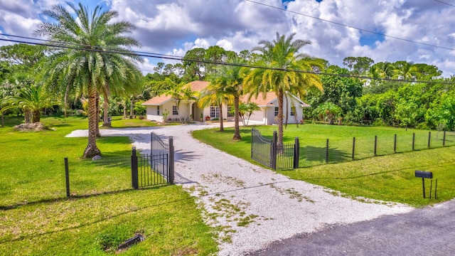 12820 87th St N, West Palm Beach, FL 33412 - view of front of house featuring gravel driveway, a gate, stucco siding, and an attached garage