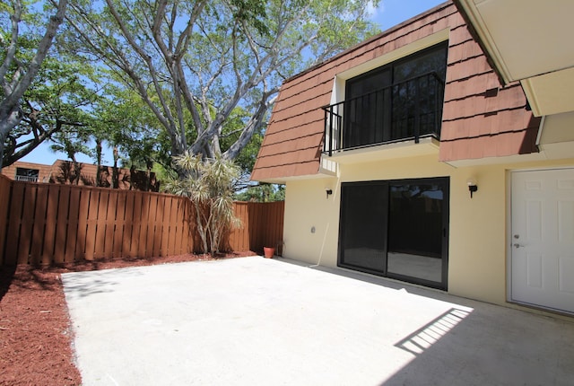 404 Live Oak Ln, Boynton Beach, FL 33436 - rear view of property featuring a balcony, a patio area, stucco siding, and fence