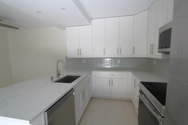 404 Live Oak Ln, Boynton Beach, FL 33436 - kitchen with a sink, white cabinets, light stone counters, and stainless steel appliances
